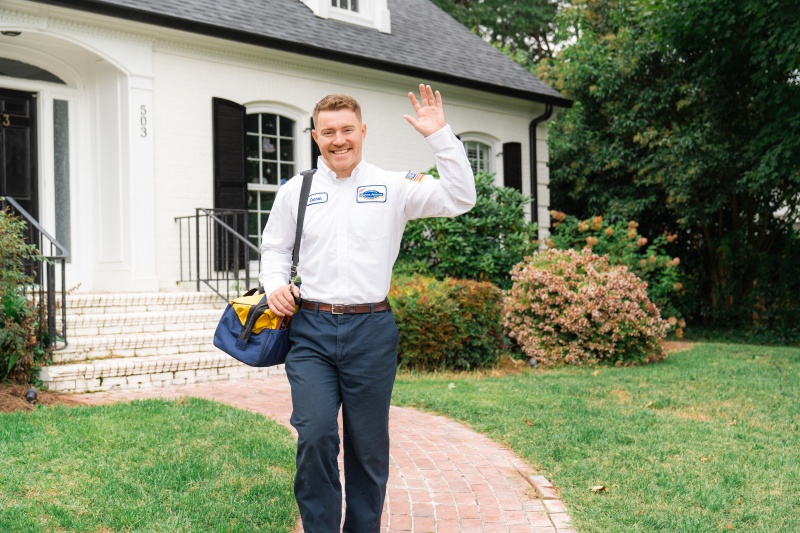 Tech walking away from customer's home waving at the camera